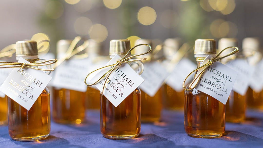 A grouping of maple syrup bottles displaying a white hang tag with gold writing.