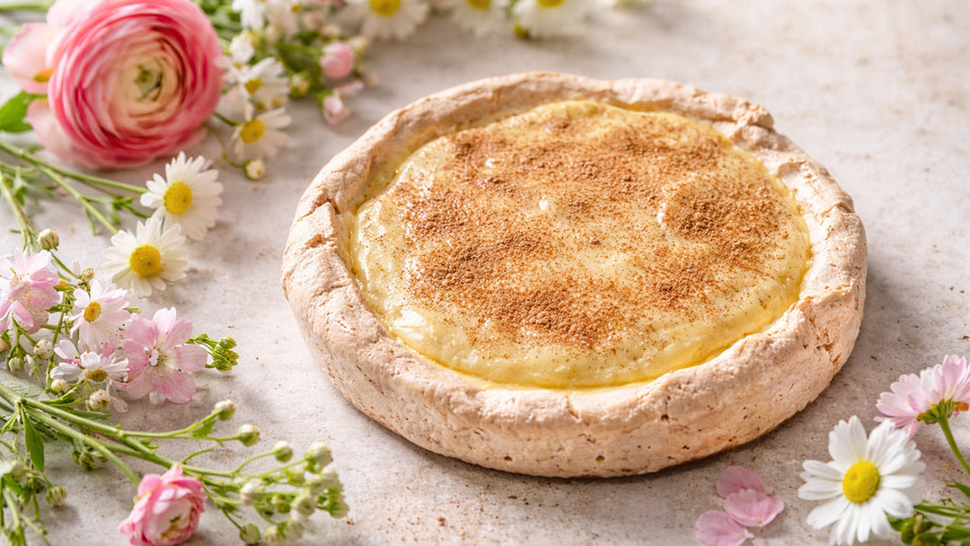 Maple mousse pie with cinnamon in a meringue crust styled with spring flowers.