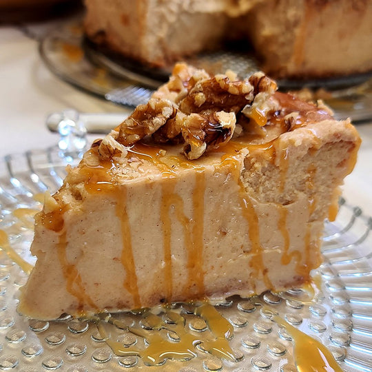 Maple Walnurt Cheesecake is plated with a drizzle of thickened maple syrup.