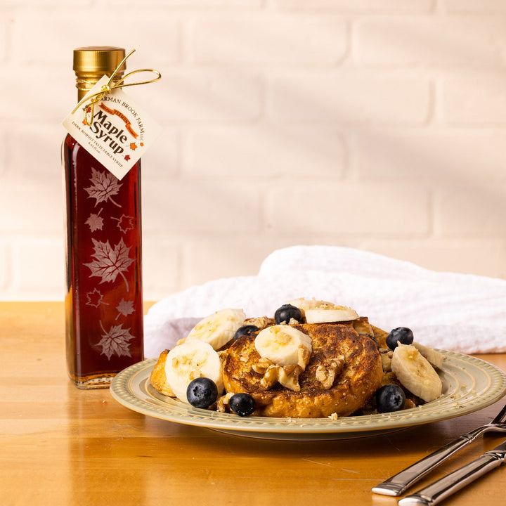 Autumn Leaf Vermont maple syrup bottle beside waffles on brunch table.