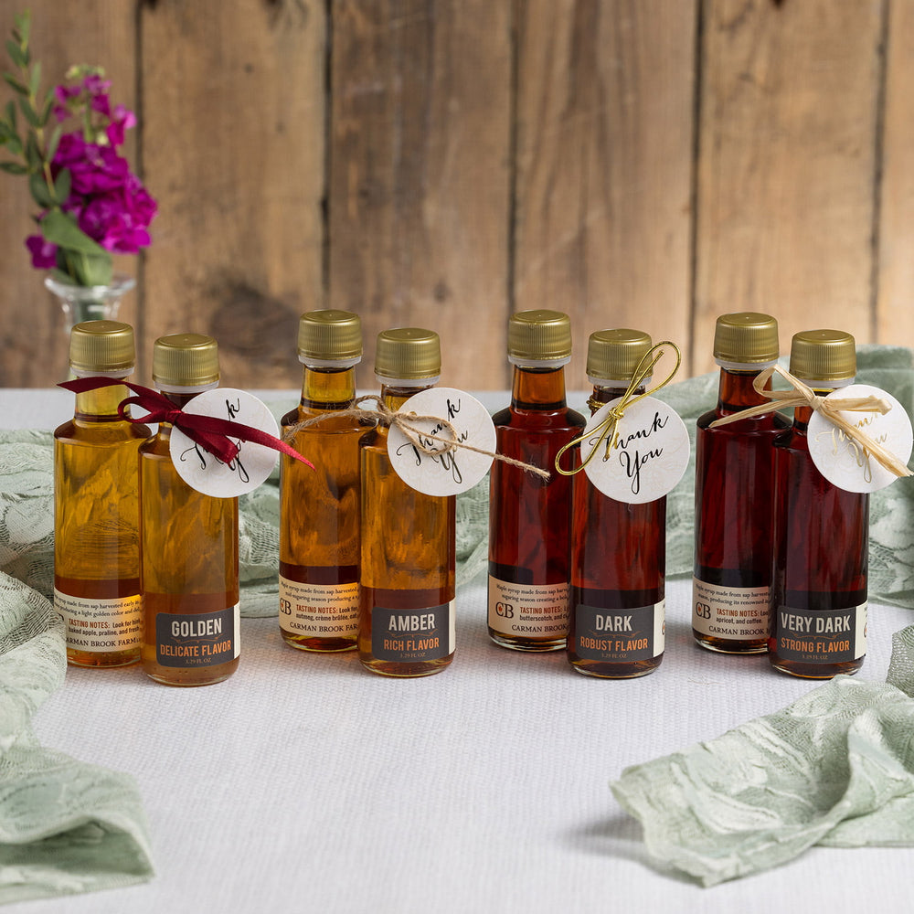 Maple syrup wedding favors displayed at table place setting.