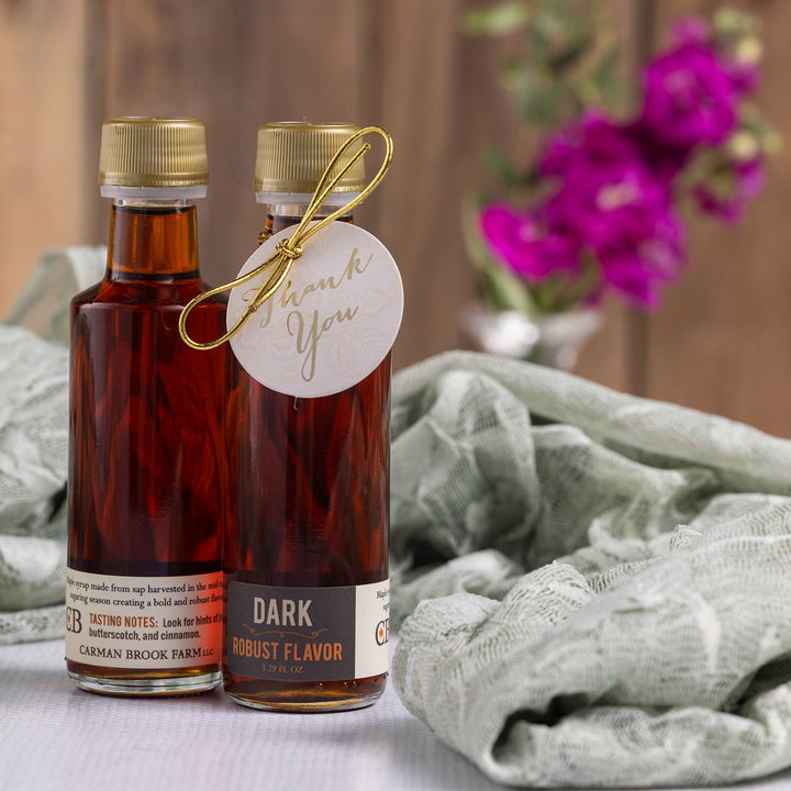 Dark robust Vermont maple syrup wedding favor bottle styled with warm tones.