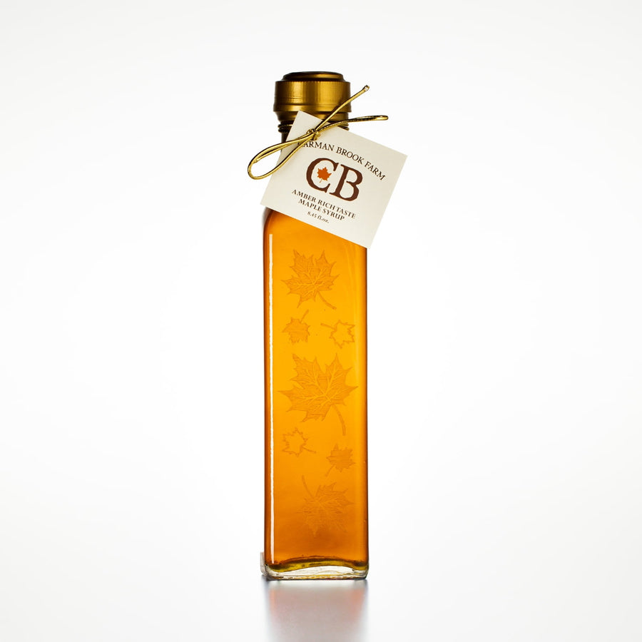 8.45 oz autumn leaf glass bottle of Vermont maple syrup isolated on white background for wedding favors.