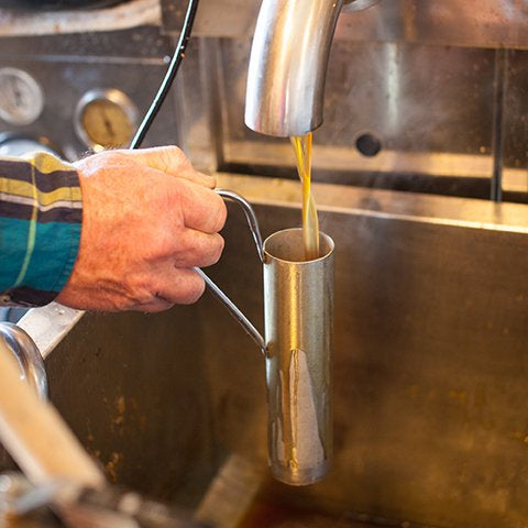 Drawing off maple syrup during production.